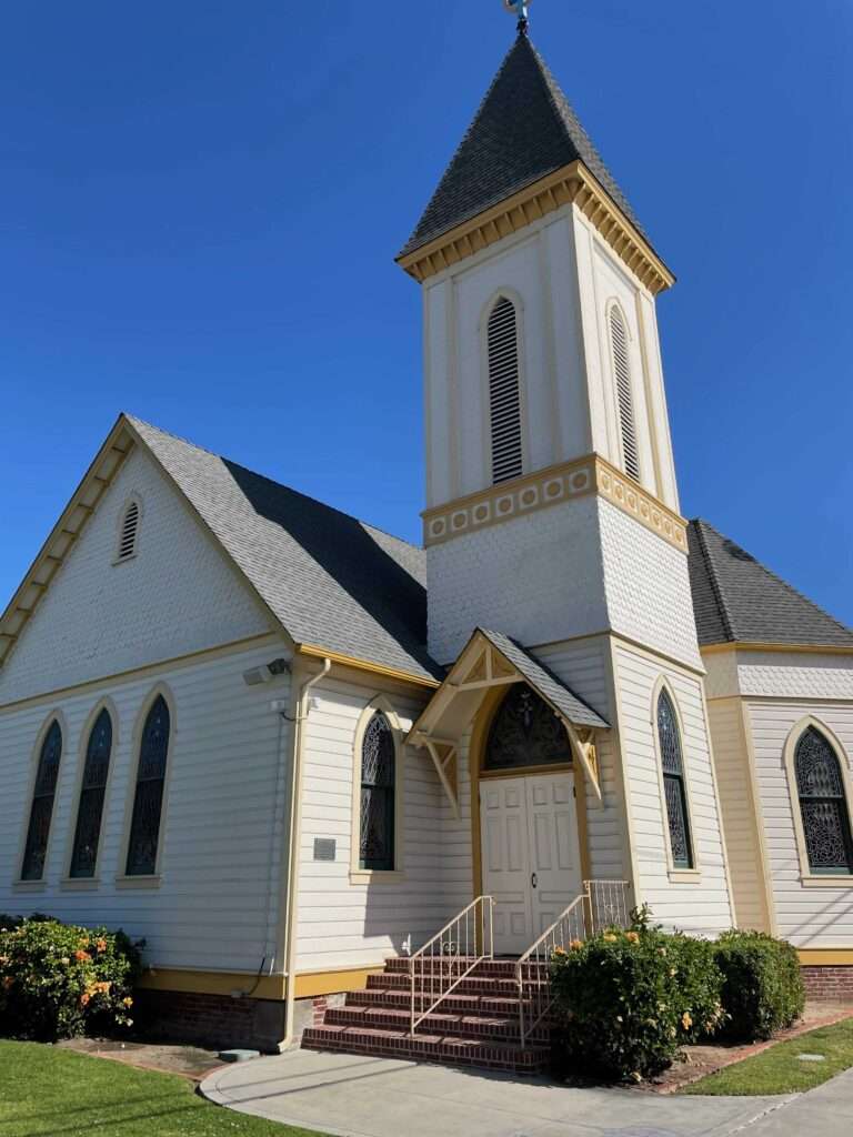 Picture of a Wooden historic church with a tall steeple and pointed windows on Coronado Island.